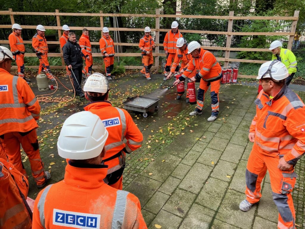 Praktischer Teil der Brandschutzschulung, mit Bauarbeitern