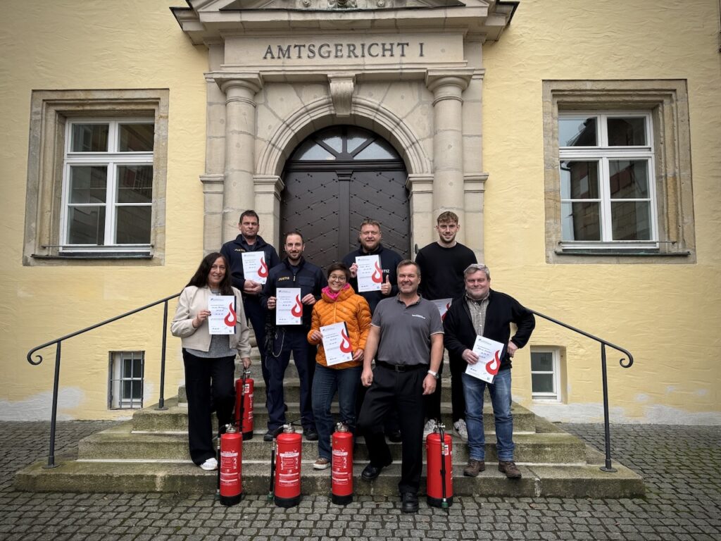 Brandschutzhelfer Ausbildung Bayern – Teilnehmende mit Zertifikaten vor einem bayerischen Amtsgericht
