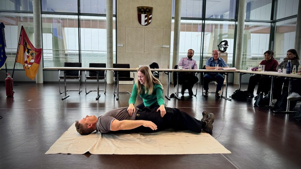 Brandschutzhelfer Ausbildung Bayern – Demonstration einer sicheren Seitenlage zur Versorgung von Betroffenen nach einem Brandereignis