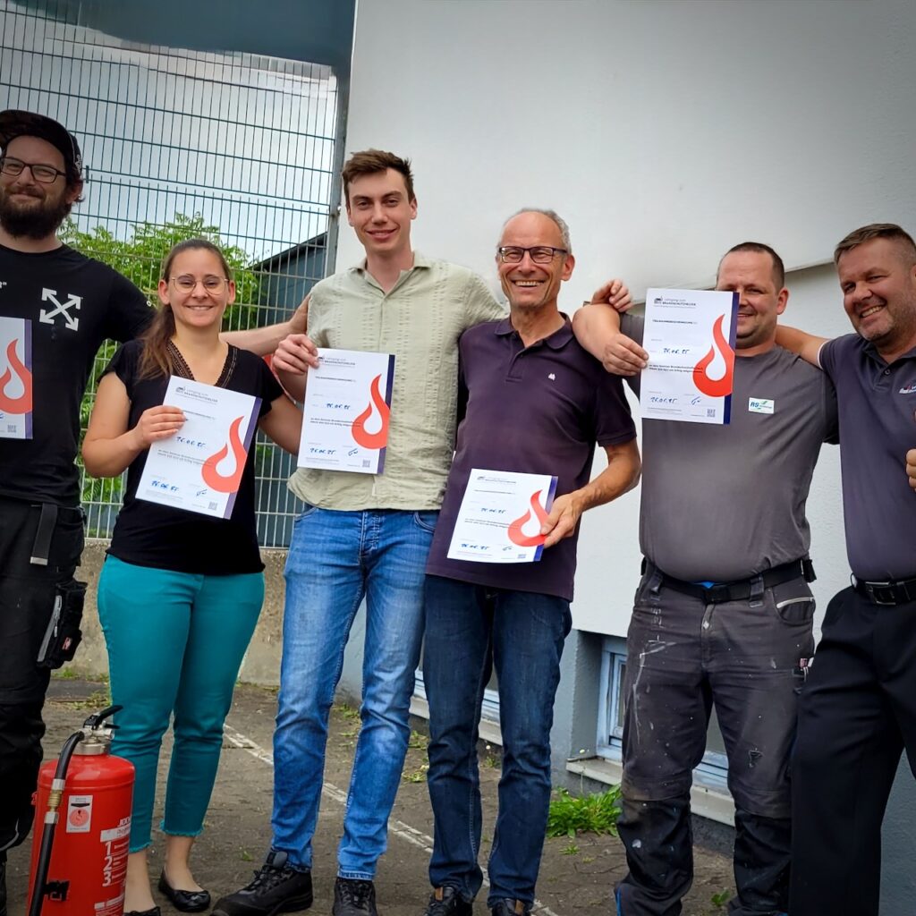 Teilnehmende nach der Brandschutzhelfer Ausbildung in Bayern mit Zertifikaten – reale Schulung durch aktive Berufsfeuerwehrmänner