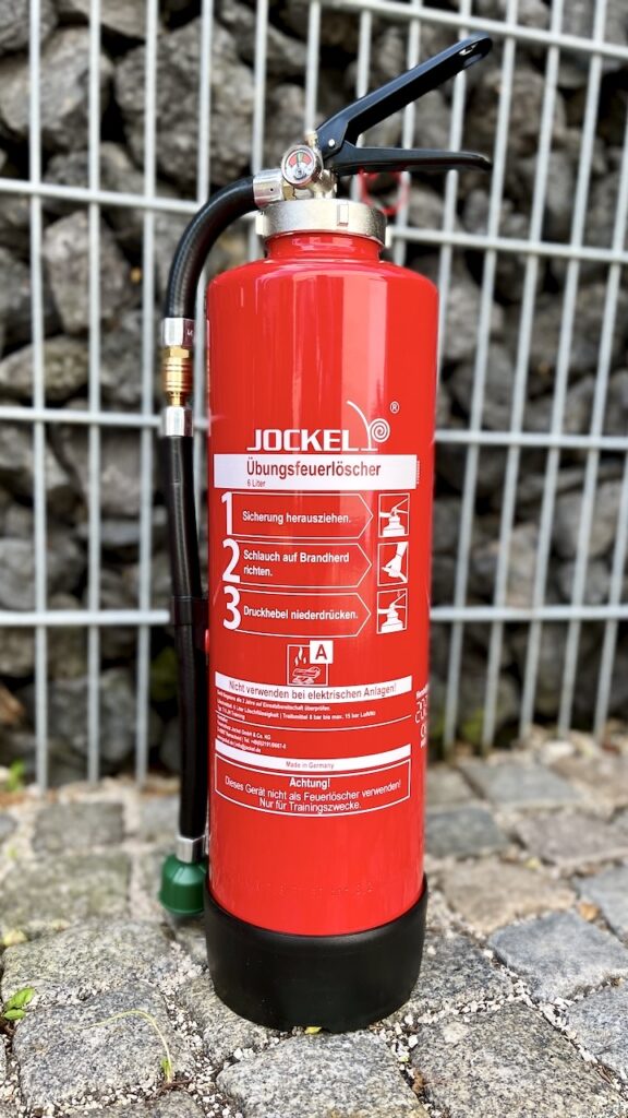 Übungsfeuerlöscher vor dunklem Hintergrund – Trainingsfeuerlöscher Detailfoto