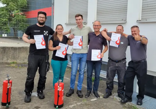 Teilnehmende erhalten ihre Zertifikate nach einem Brandschutzhelfer Inhouse Kurs