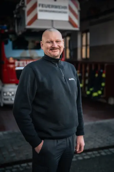 Uwe Wahl, Brandinspektor - Atemschutz und Tauchausbildung bei der Berufsfeuerwehr; Ausbilder für Brandschutzhelfer vor einer Drehleiter
