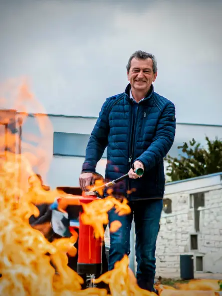 Ausgebildeter Beschäftigter im Betrieb mit Feuerlöscher als Beispiel für einen Brandschutzhelfer