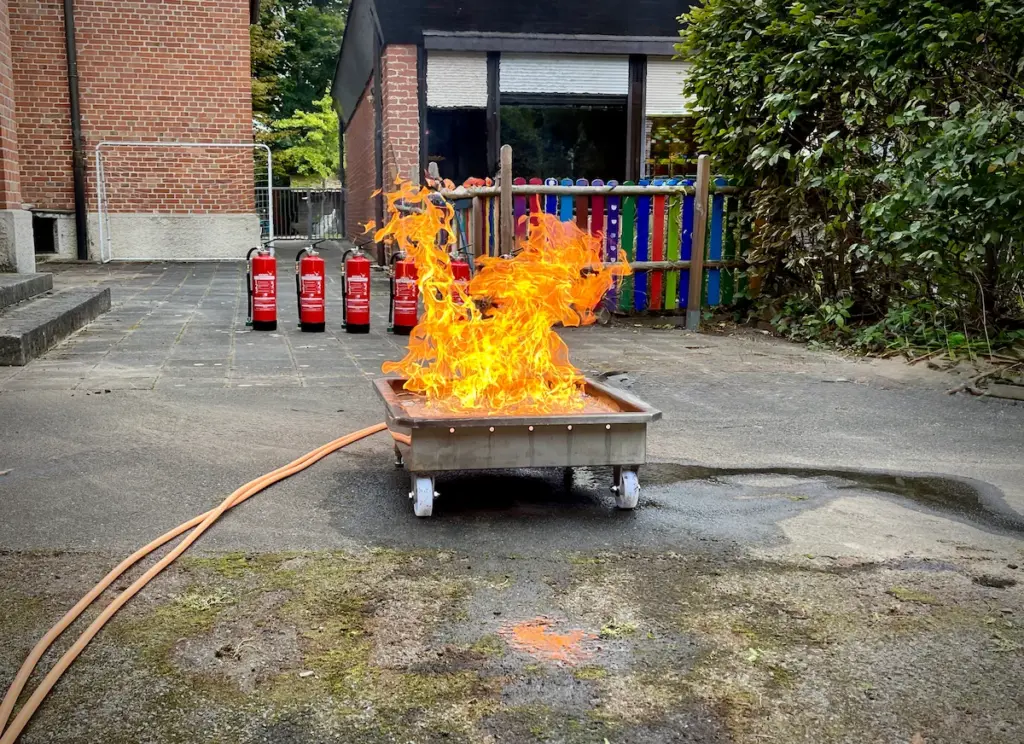 Übungsfläche für Brandschutzhelfer Kurs mit Brandsimulator und Feuerlöschern im Betrieb