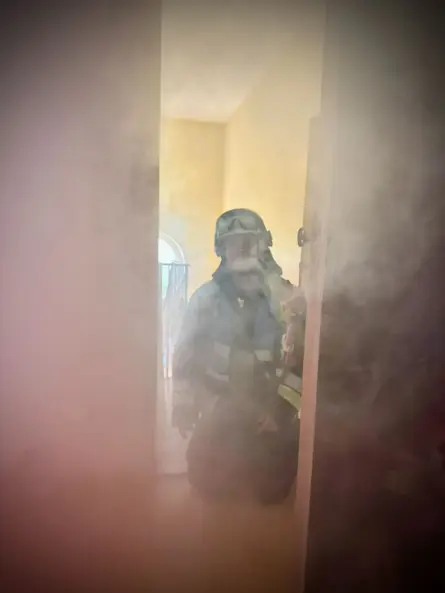 Berufsfeuerwehrmann Thomas Till bewegt sich während eines Einsatztrainings durch einen stark verrauchten Bereich und demonstriert die eingeschränkte Sicht im Brandfall.