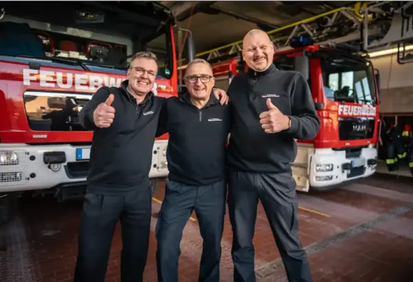 Berufsfeuerwehrmänner hinter der Online-Terminbuchung für Brandschutzhelfer-Schulungen
