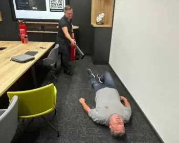 Oberbrandmeister Thomas Till demonstriert während einer Brandschutzhelfer-Ausbildung den Umgang mit Feuerlöschern bei einem simulierten Personenbrand.