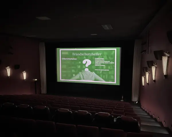 Brandschutzhelfer-Kurs in einem Kinosaal mit Präsentation auf der großen Leinwand