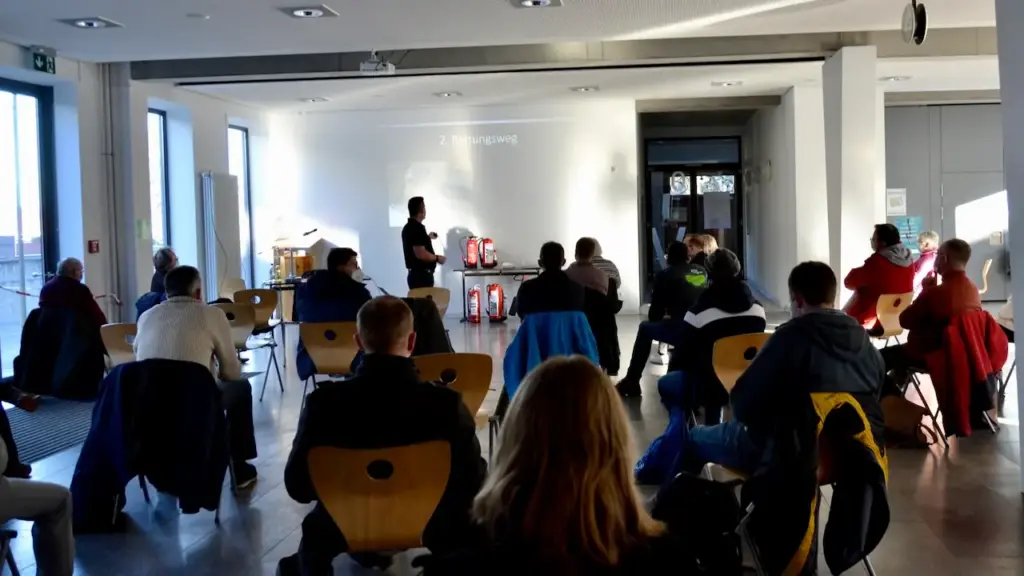 Brandschutzhelfer-Kurs in einer Schul-Aula mit Teilnehmenden und Ausbilder