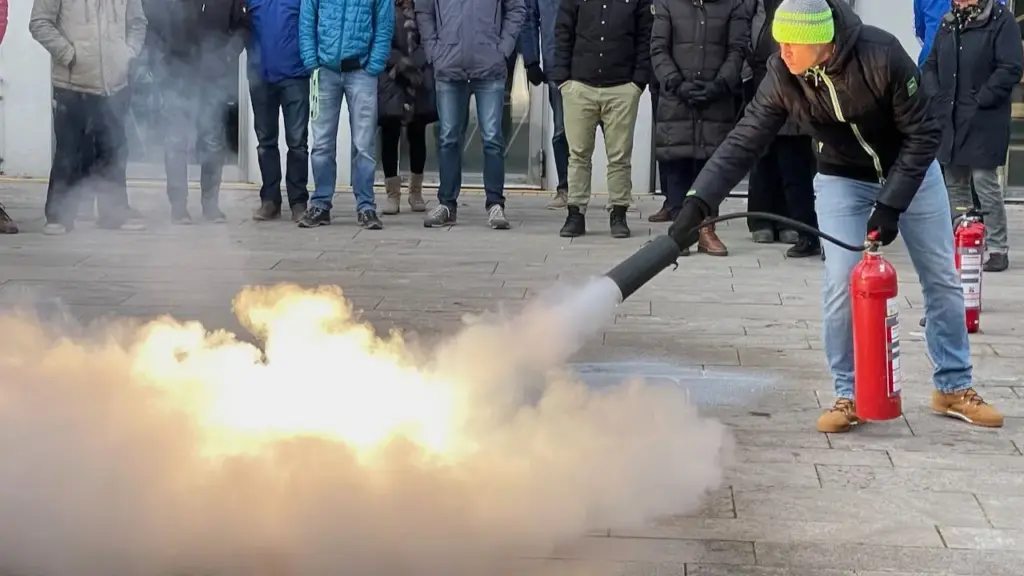 Teilnehmer löscht bei einer Brandschutzhelfer-Ausbildung ein Übungsfeuer mit einem Feuerlöscher