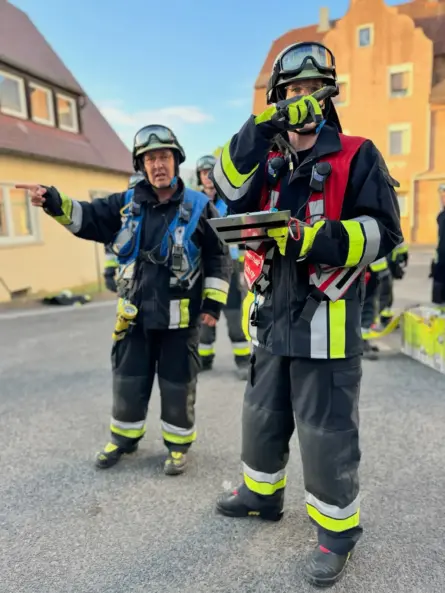 Thomas Till in blauer Gruppenführer-Weste der Berufsfeuerwehr bei der Führung und Koordination von Einsatzkräften an einer Einsatzstelle