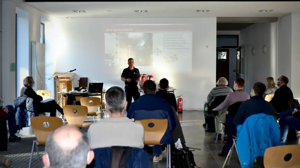 Lehrkräfte bei der Theorie einer Brandschutzhelfer-Ausbildung in der Aula einer Schule